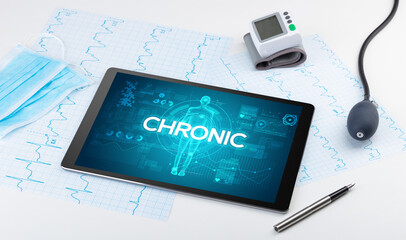Tablet pc and doctor tools with CHRONIC inscription, coronavirus concept