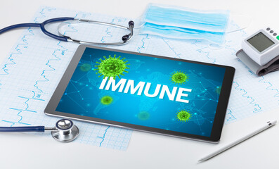 Close-up view of a tablet pc with IMMUNE inscription, microbiology concept
