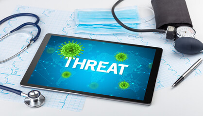 Close-up view of a tablet pc with THREAT inscription, microbiology concept