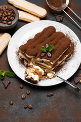 portion of Classic tiramisu dessert and savoiardi cookies on concrete background