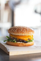 Freshly prepared burger on wooden board with copy space