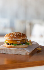 Freshly prepared burger on wooden board with copy space