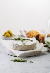 Camembert cheese with rosemary on a white background