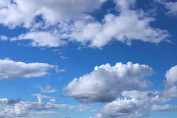 Naklejka na ściany i meble White-gray fluffy clouds in a blue sky. Selective focus.