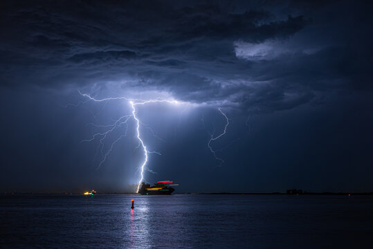 Ship sails across a river during a severe lightning storm