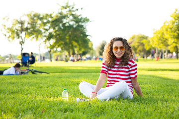 Fototapeta premium Young woman sitting on the grass