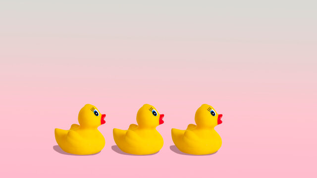 Yellow rubber ducks on a pastel pink background.