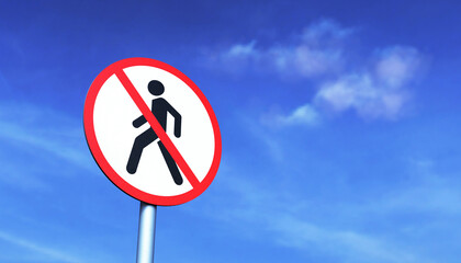 No pedestrian traffic sign on a metal pole against a blue sky
