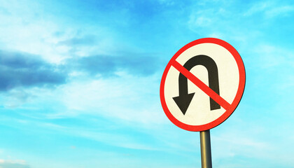 No U-Turn road sign on a metal pole against the blue sky