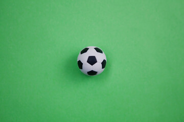 Miniature of soccer ball on green background. Football development concept, training prices, physical development of child.