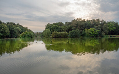 Fototapeta na wymiar Tsaritsino park - pond andf reflection in water , ducks swimming- beginning of autumn