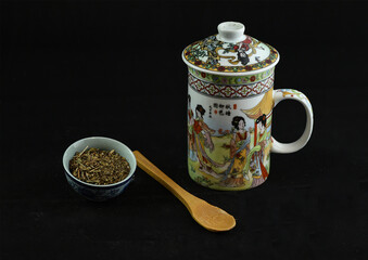 tea in leaves with cup and wooden spoon