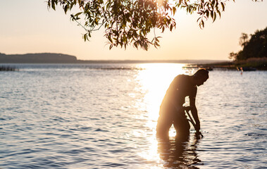 Mężczyzna nad jeziorem, zachód słońca, Kaszuby