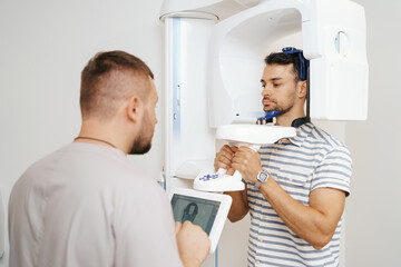 Doctor and patient using x-ray machine. Computer diagnostics. Dental tomography