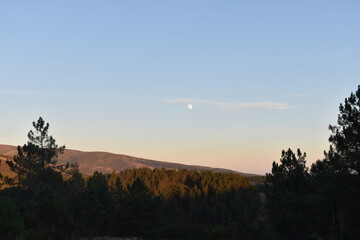Landscape of a mountain with full moon by day
