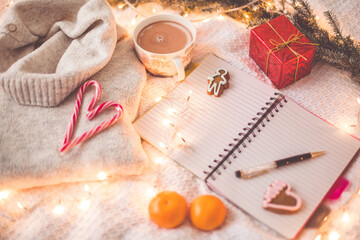 Hot chocolate with marshmallows and cinnamon, notepad, Christmas decorations on a light background. Christmas inspiration planning concept.