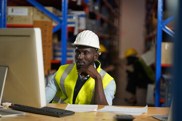 man manager with computor warehouse worker checks the inventory boxes.