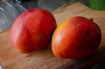 close up on mango fruit over a wooden cutting board