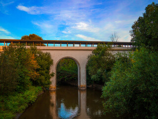 Fototapeta premium The old bridge crosses the river at sunset