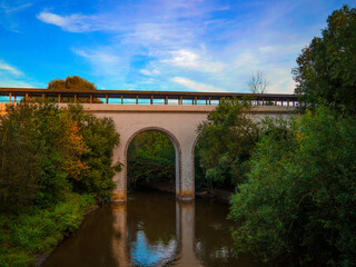The old bridge crosses the river at sunset