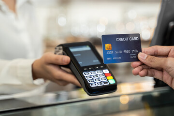 Customer using credit card for payment at cashier in cafe restaurant.