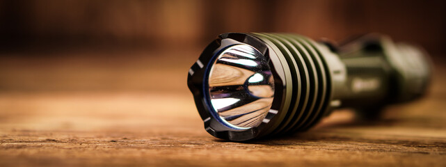 Obraz na płótnie Canvas Banner detail close up of flashlight on a blurred wooden background. 