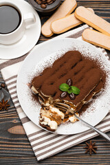 portion of Classic tiramisu dessert and savoiardi cookies on wooden background