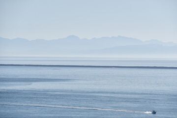 Boat out on the pacific ocean on a hazy day.