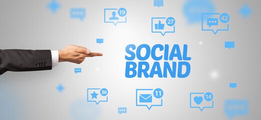 Close-Up of cropped hand pointing at SOCIAL BRAND inscription, social networking concept