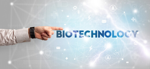 Hand pointing at BIOTECHNOLOGY inscription, modern technology concept