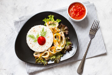 Delicious stewed squid with rice in a dark dish.