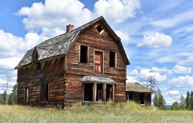 Fototapeta na wymiar Old abandoned wooden house or barn. Empty, broken windows.