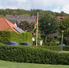 Deutsche Fahne an Fahnenmast in Wohnsiedlung