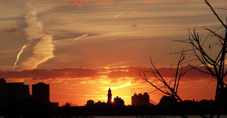 Fototapeta na wymiar Red orange sunset over the New York city. dark silhouettes of buildings. Impressive night cityscape.