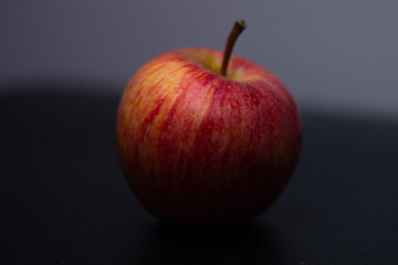 One red fresh apple on a black background. Healthy fruit and breakfast.