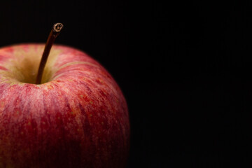 One red fresh apple on a black background. Healthy fruit and breakfast.