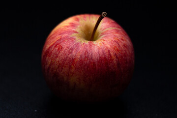 One red fresh apple on a black background. Healthy fruit and breakfast.