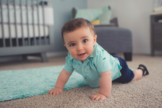 Little boy baby playing ins room on a carpet by his crib  stock photo royalty free 