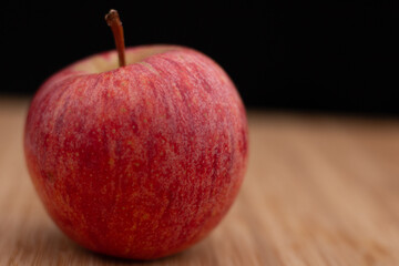 One fresh red apple on a wooden background. Fresh and healthy breakfast fruit.
