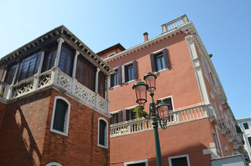 
typical Venetian palaces facade with green lamppost in the foreground