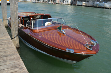 
wooden motorboat moored to a wooden pier