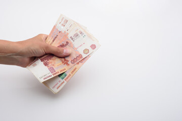 Hand holds a bundle of Russian five thousandth bills
