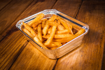 Closeup focus shot of delicious-looking fries on a wooden table