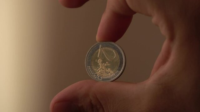 euro coin roll between fingers
