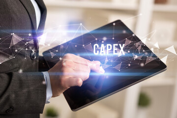 Close up hands using tablet with CAPEX inscription, modern business technology concept