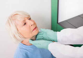An elderly woman have a thyroid check. Diagnosis of diseases of the endocrine system,...