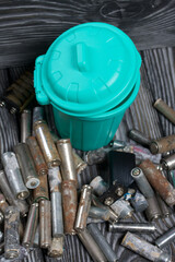 Corroded used batteries. Nearby is a trash can. On pine boards. Disposal of hazardous waste.