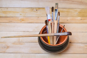 Artistic brushes in a clay pot