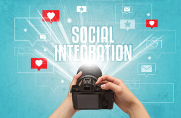 Fototapeta na wymiar Close-up of a hand taking photos with SOCIAL INTEGRATION inscription, social media concept