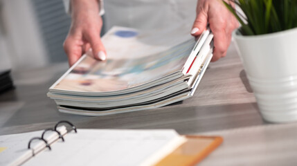 Female hands holding magazines